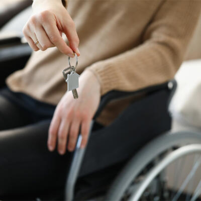 personne en fauteuil roulant qui tient ses clés de maisonx600